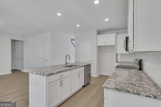 kitchen with a kitchen island with sink, sink, white cabinets, and appliances with stainless steel finishes