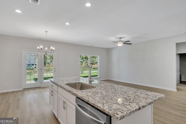 kitchen featuring sink, decorative light fixtures, stainless steel dishwasher, an island with sink, and white cabinets