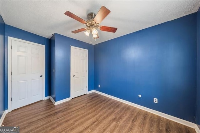 unfurnished bedroom with hardwood / wood-style flooring, ceiling fan, and a textured ceiling