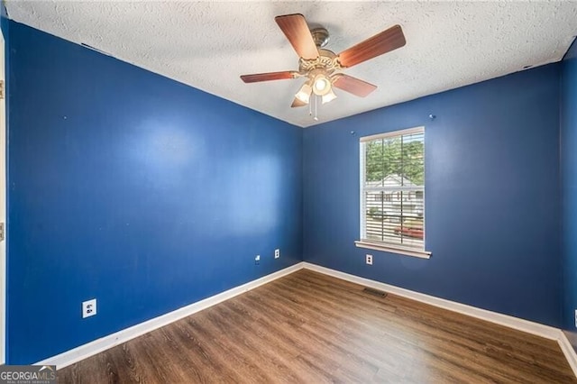 spare room with hardwood / wood-style floors, a textured ceiling, and ceiling fan