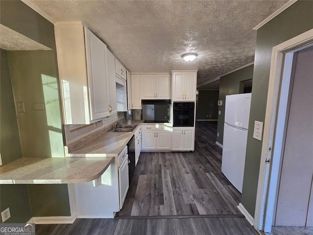 kitchen with dark wood-type flooring, white cabinetry, white refrigerator, kitchen peninsula, and oven