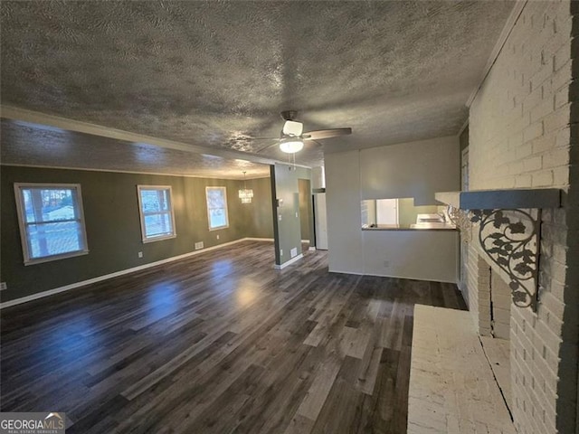 unfurnished living room featuring a brick fireplace, ceiling fan with notable chandelier, a textured ceiling, and dark hardwood / wood-style flooring