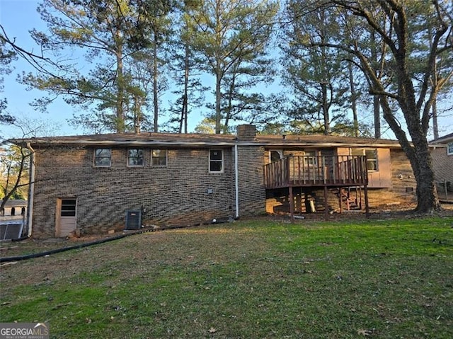 rear view of property with a wooden deck, a lawn, and central air condition unit