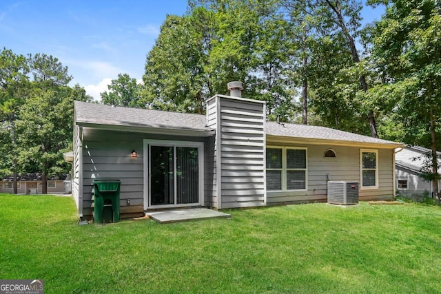 back of property featuring central AC and a lawn