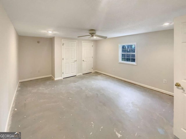 unfurnished bedroom with multiple closets, concrete floors, and ceiling fan