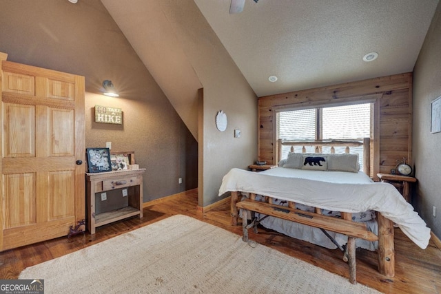 bedroom featuring a textured ceiling, vaulted ceiling, and wood-type flooring