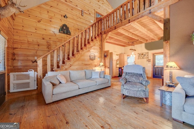 living room featuring wood-type flooring, wooden walls, wooden ceiling, and high vaulted ceiling