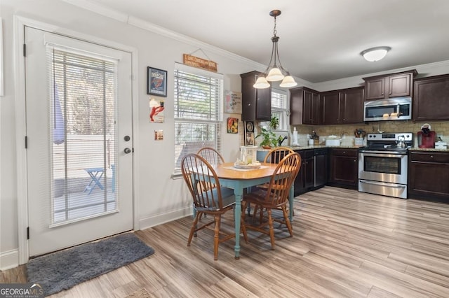 dining space with crown molding and light hardwood / wood-style flooring