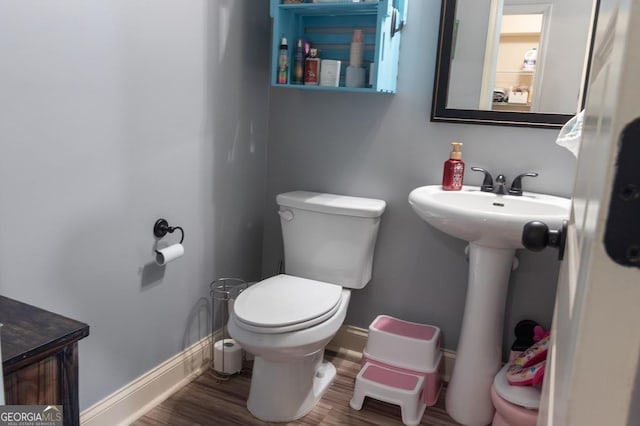 bathroom with hardwood / wood-style flooring, toilet, and sink