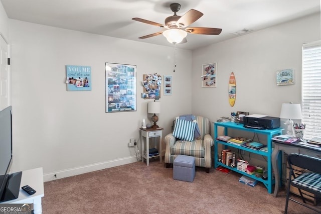 living area featuring ceiling fan and carpet