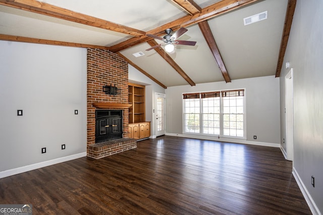 unfurnished living room featuring ceiling fan, dark hardwood / wood-style flooring, lofted ceiling with beams, and a brick fireplace