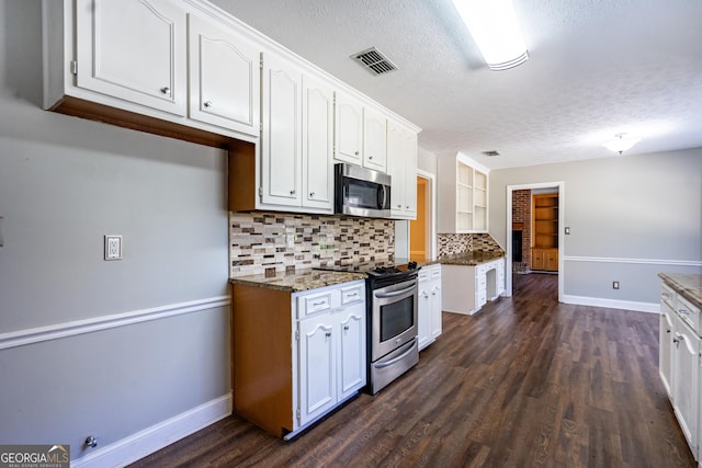 kitchen with white cabinetry, stainless steel appliances, a textured ceiling, dark hardwood / wood-style flooring, and decorative backsplash