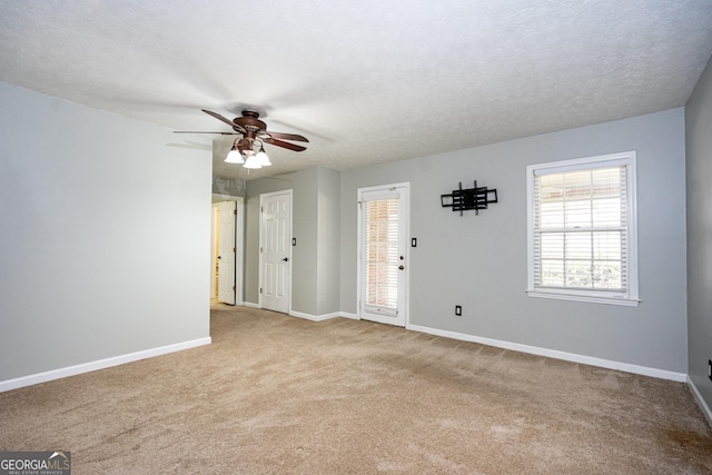 carpeted spare room with ceiling fan and a textured ceiling