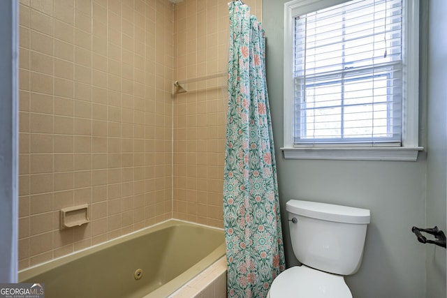 bathroom featuring shower / tub combo and toilet