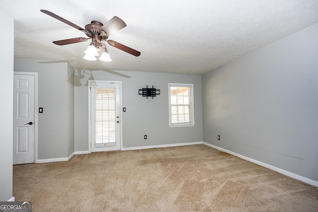 carpeted spare room featuring ceiling fan and a textured ceiling