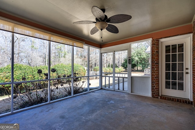 unfurnished sunroom with ceiling fan