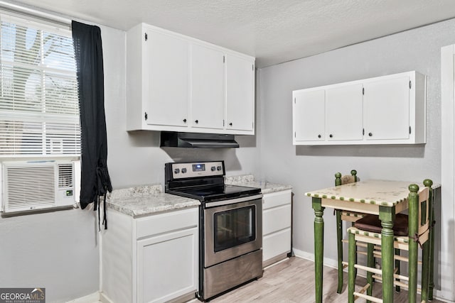 kitchen featuring stainless steel electric range, cooling unit, white cabinets, a textured ceiling, and light hardwood / wood-style flooring