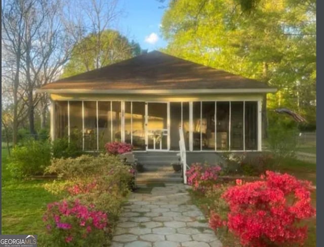 back of property with a sunroom