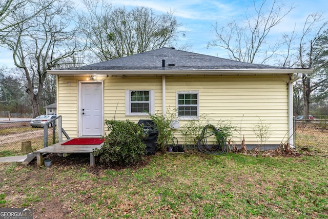 rear view of property featuring a yard