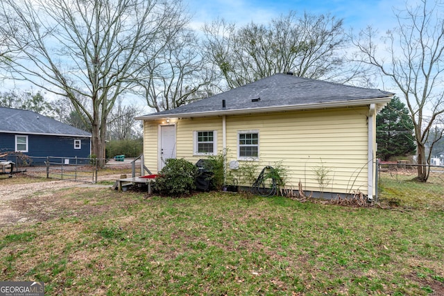 back of house featuring a lawn