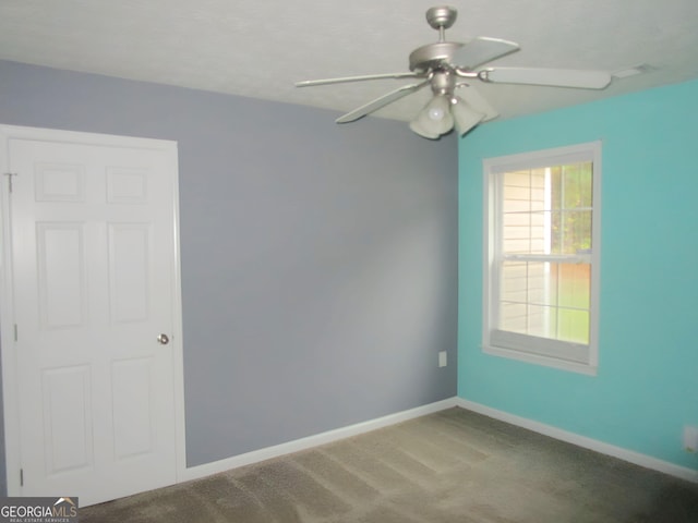 carpeted spare room with ceiling fan