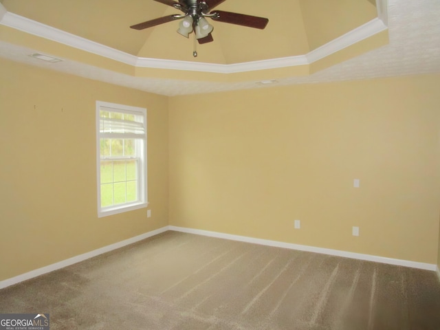 carpeted empty room featuring ornamental molding, ceiling fan, and a tray ceiling