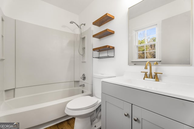 full bathroom with hardwood / wood-style flooring, vanity, washtub / shower combination, and toilet