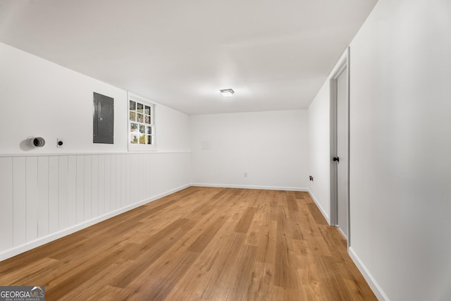 basement with electric panel and light hardwood / wood-style floors