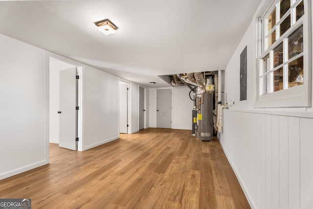 basement featuring water heater and light wood-type flooring