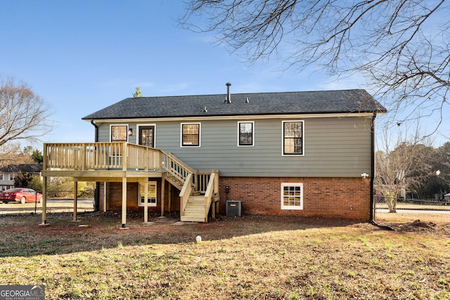 rear view of property featuring a wooden deck, central AC, and a lawn