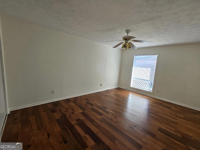 spare room featuring ceiling fan, dark wood-type flooring, and a textured ceiling