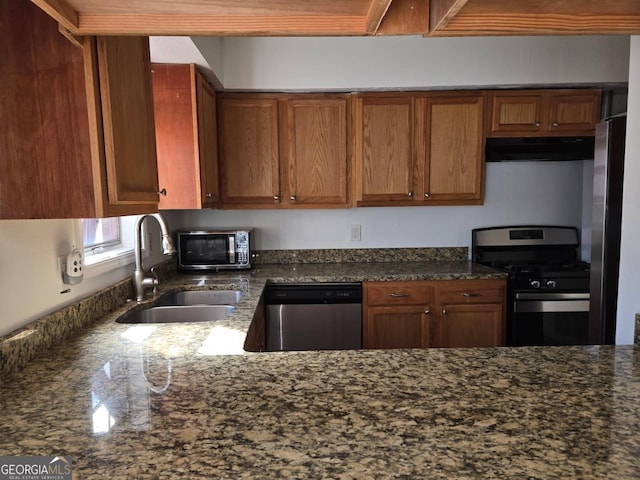 kitchen with stainless steel appliances, sink, and dark stone countertops