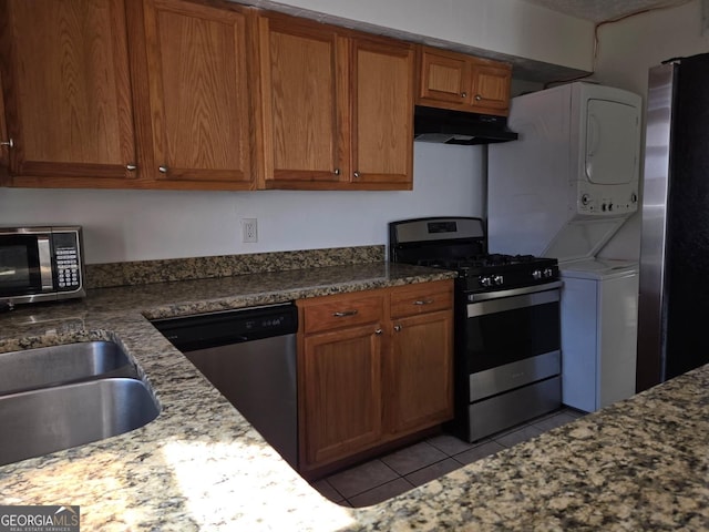 kitchen with light tile patterned flooring, appliances with stainless steel finishes, sink, and dark stone counters