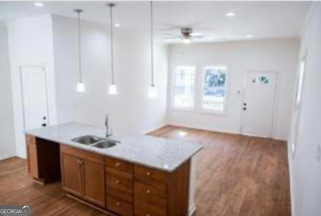 kitchen with sink, wood-type flooring, hanging light fixtures, and ceiling fan