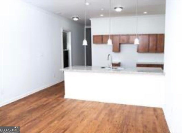 kitchen featuring hardwood / wood-style floors, sink, and hanging light fixtures