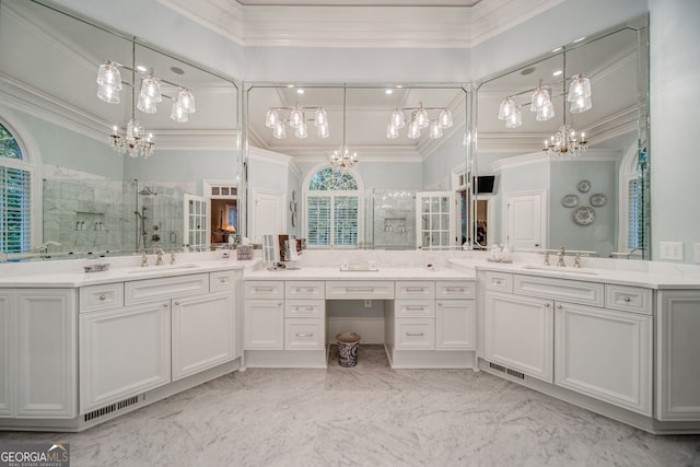 bathroom with a chandelier, ornamental molding, a shower with shower door, and vanity