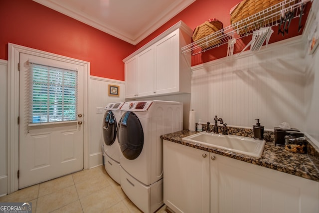 clothes washing area with sink, cabinets, light tile patterned floors, washing machine and clothes dryer, and crown molding