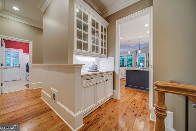 kitchen featuring crown molding, white cabinets, and light wood-type flooring