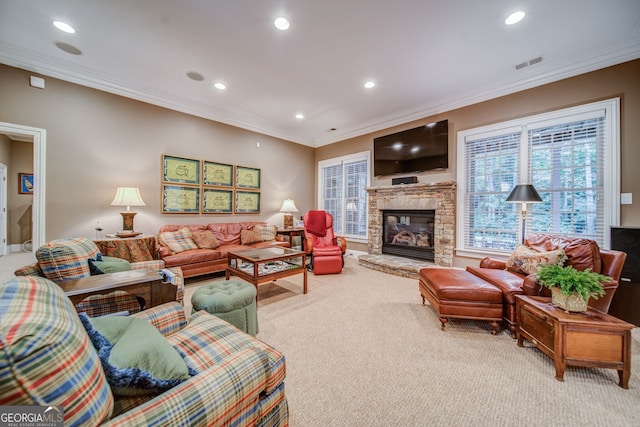 living room featuring crown molding, a stone fireplace, and light colored carpet