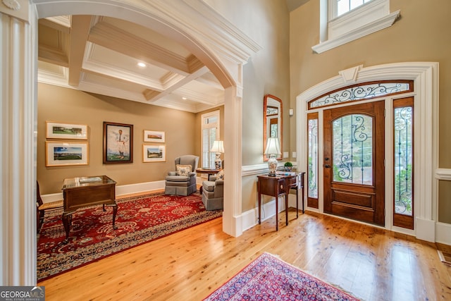 foyer with hardwood / wood-style flooring, crown molding, coffered ceiling, and beamed ceiling