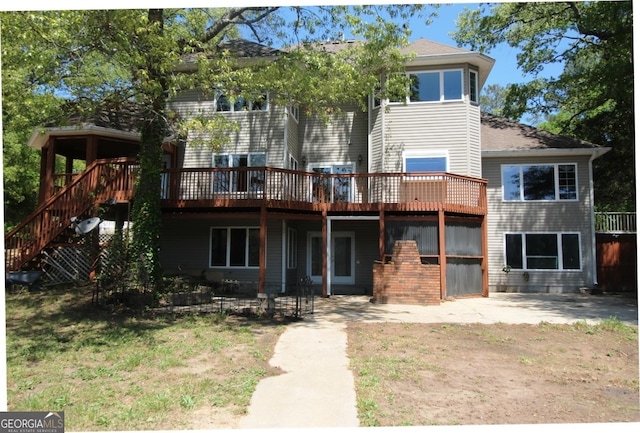 view of front facade with a wooden deck, stairs, and a patio