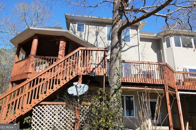 rear view of property with stairway and a wooden deck