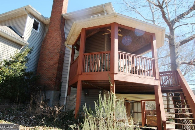 back of property featuring a chimney and stairway