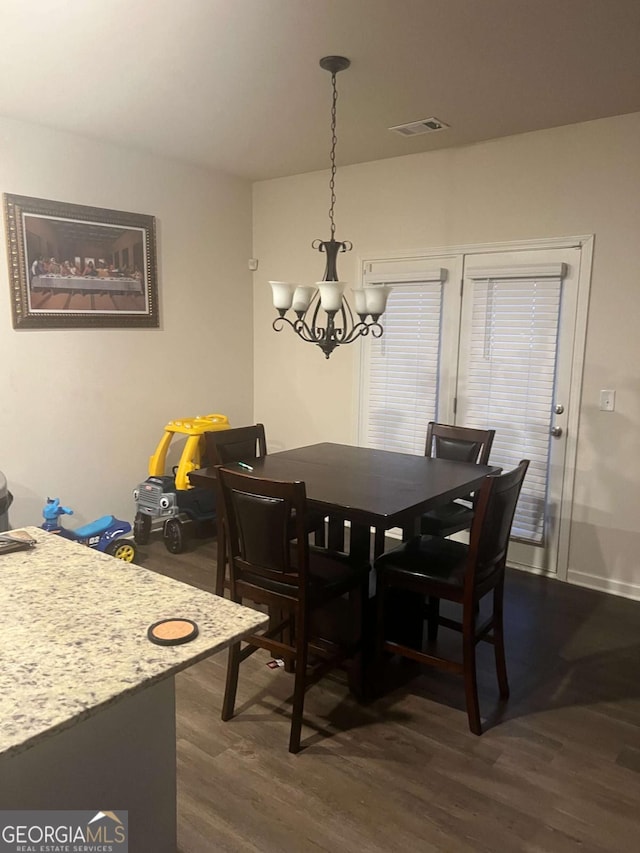 dining room featuring dark wood-type flooring and a chandelier