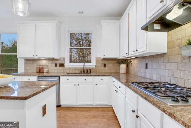 kitchen with sink, stainless steel appliances, light hardwood / wood-style floors, decorative backsplash, and white cabinets