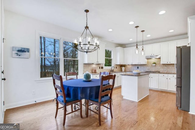 dining area featuring a notable chandelier and light hardwood / wood-style floors