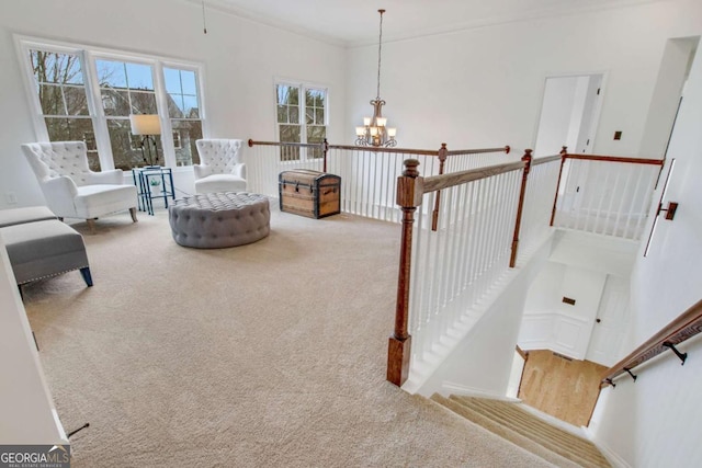 sitting room featuring ornamental molding, light colored carpet, and a chandelier