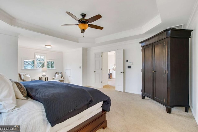 carpeted bedroom with ceiling fan, ornamental molding, and a raised ceiling