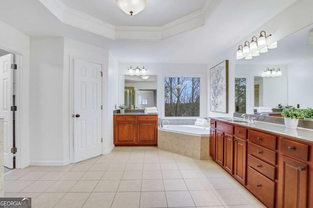 bathroom with ornamental molding, vanity, a raised ceiling, tiled tub, and tile patterned flooring