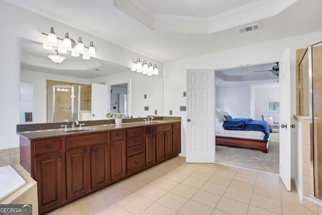 bathroom with crown molding, tile patterned floors, and a tray ceiling